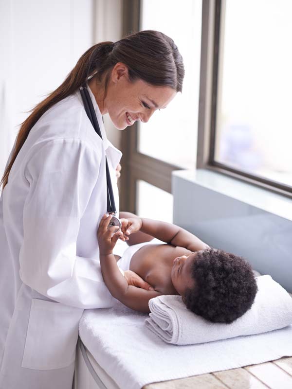 Pediatra e criança usando máscaras de proteção